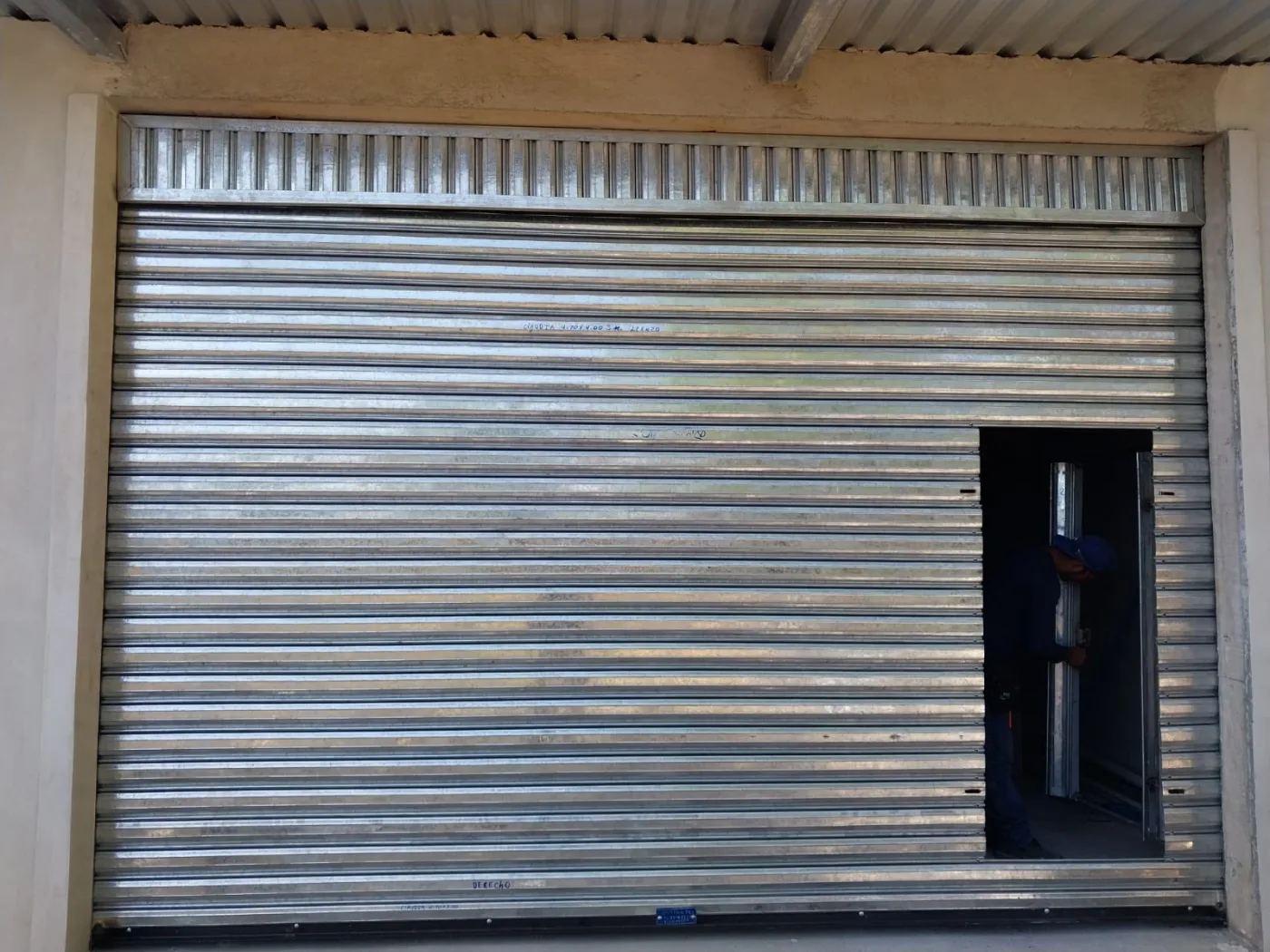 Cortina metálica con puerta peatonal